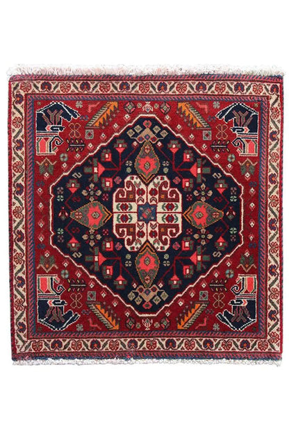 Qashqai rug by Poschti: completely red rug with a dark blue ornamental medallion.