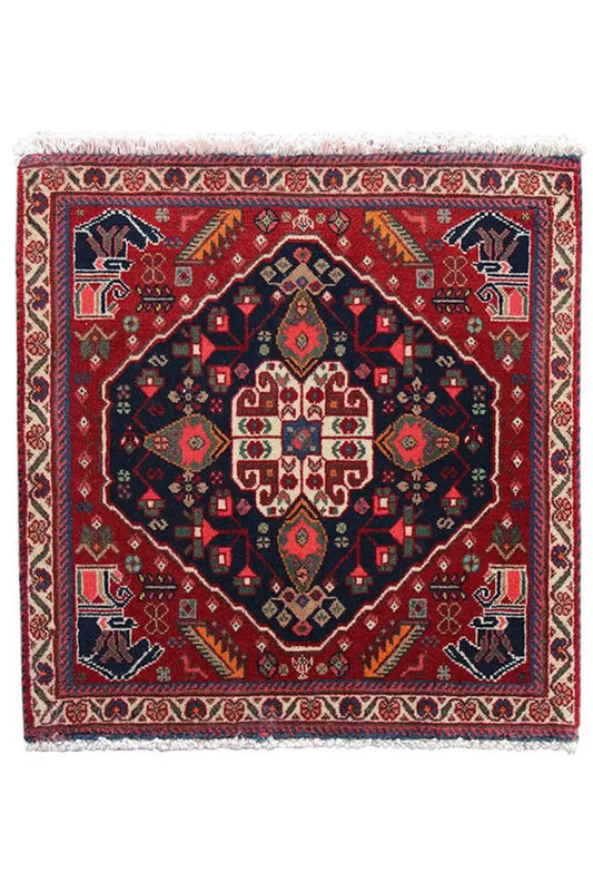 Qashqai rug by Poschti: completely red rug with a dark blue ornamental medallion.