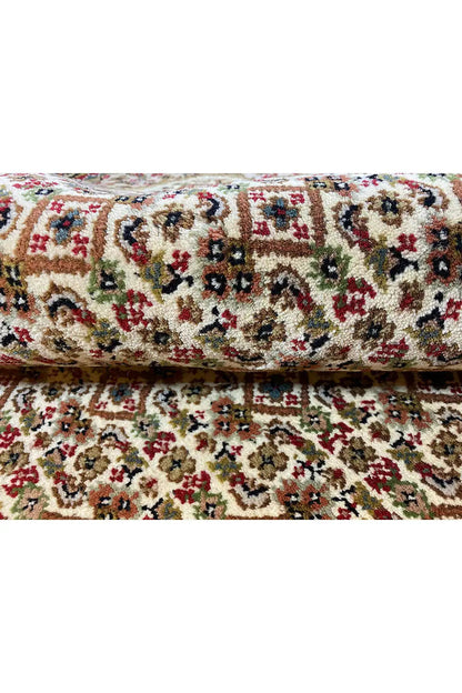 Rug with a multicolored tapestry pattern, curved edge, and dense pile structure
