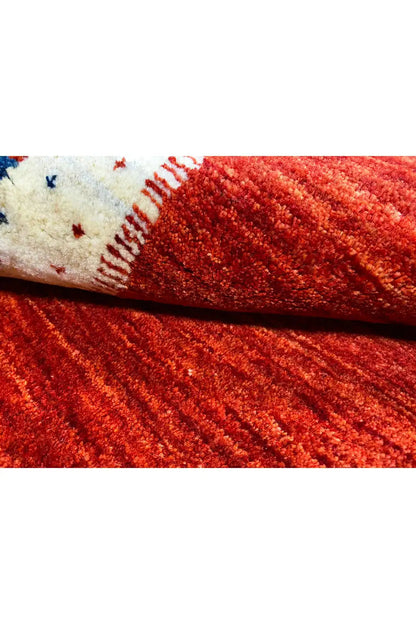 Gabbeh rug detail, red pile with a rolled edge and white seam area