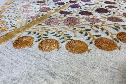 Close-up of a Gabbeh rug: circular ornaments and golden vines in purple and brown tones on a light background