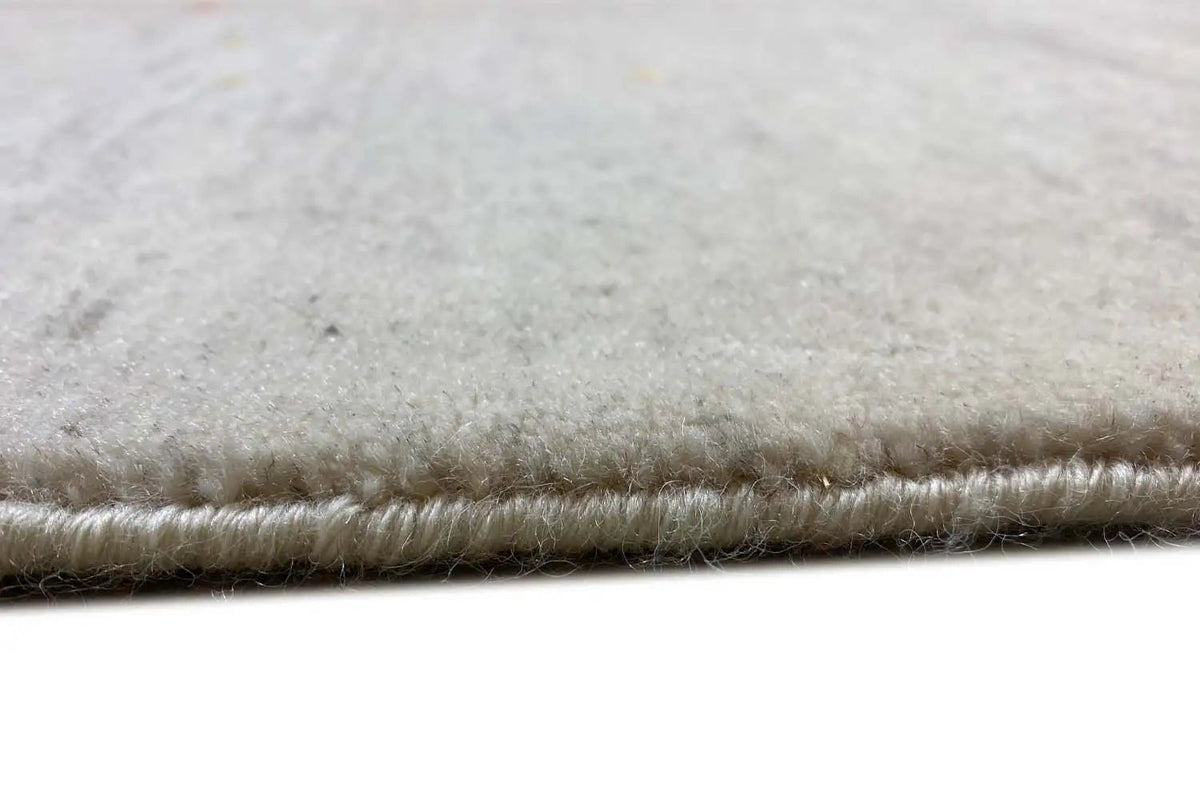 Gabbeh rug with bound pile and fringes along the edge, light beige color