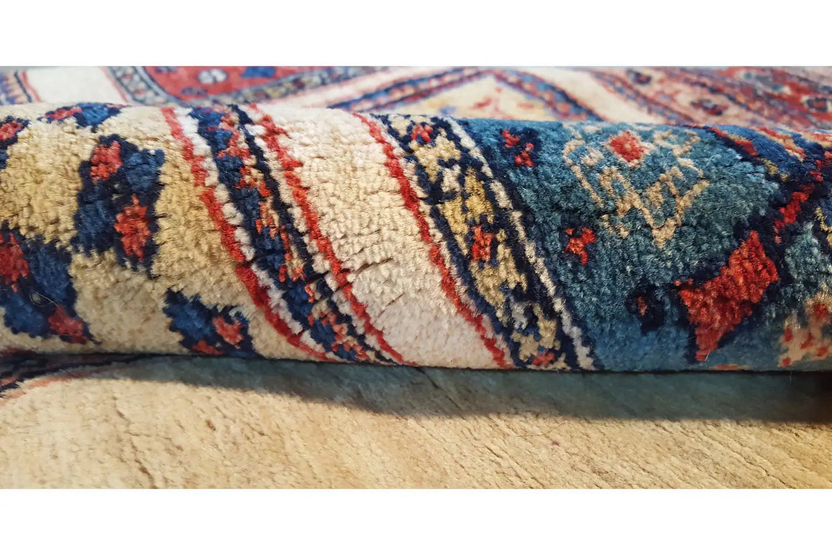 Rug edge with short fringes and a blue-red pattern on a light background