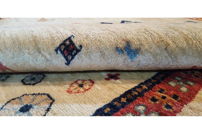 Short-pile rug with a cream-colored background and blue-and-red patterned ornament, close-up view