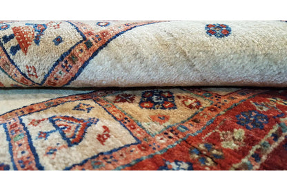 Close-up of a rug with an ornamental border pattern in red, blue, and beige