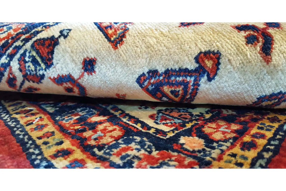 Small rug: cream-colored pile with blue and red ornaments and a border