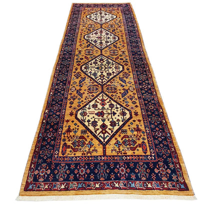 Runner rug with an ornamental pattern in gold, dark blue, and red, with bound edges