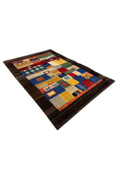 Gabbeh rug viewed obliquely from the front: dark background, colorful patchwork design
