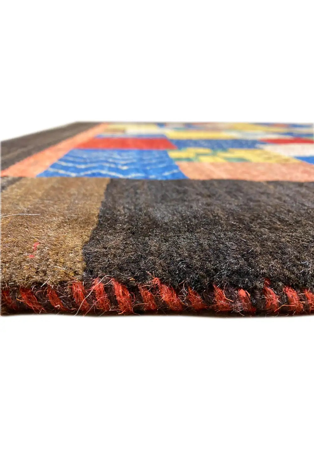 Close-up of the rug edge: dense pile, multicolored patterned area with relief
