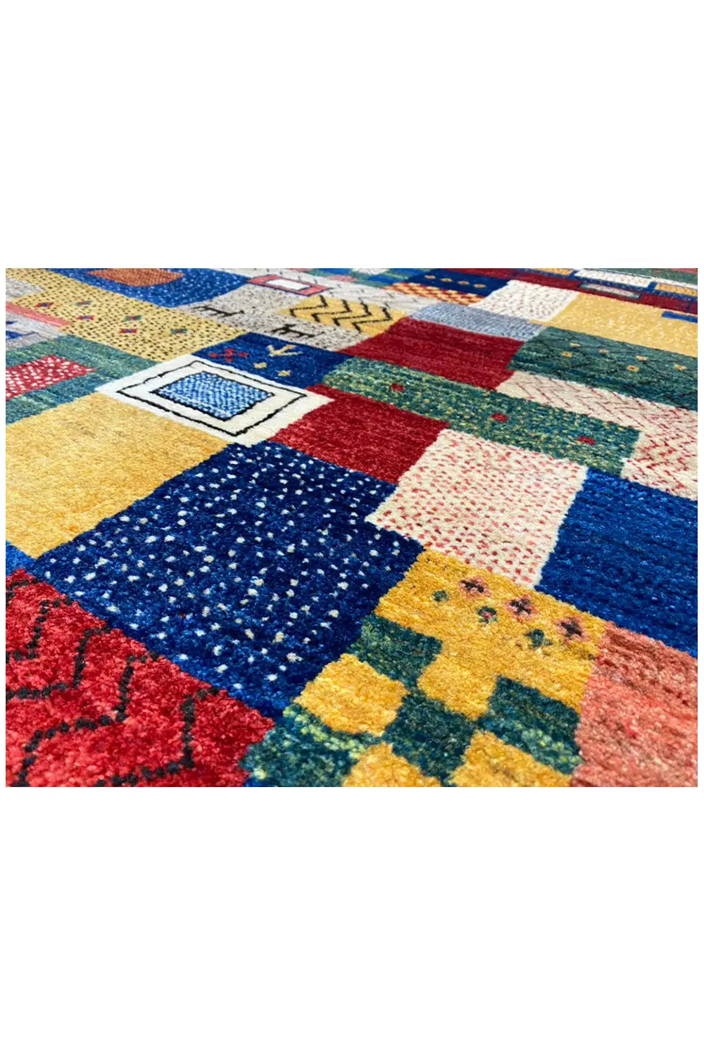 Close-up of the carpet surface: square patchwork sections in blue, red, green, and yellow