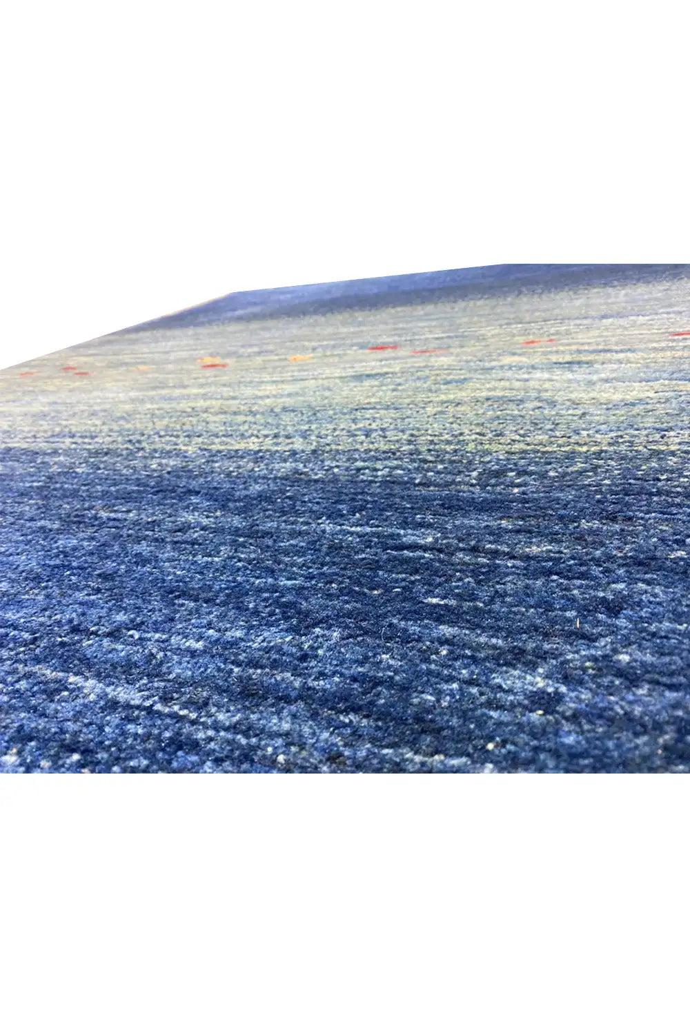 Close-up: blue carpet with a patterned pile texture and colorful dots in the stripe