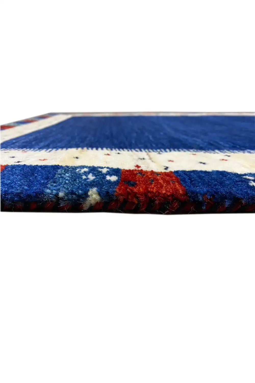 Gabbeh rug edge detail: blue pile pattern, cream border, red accent