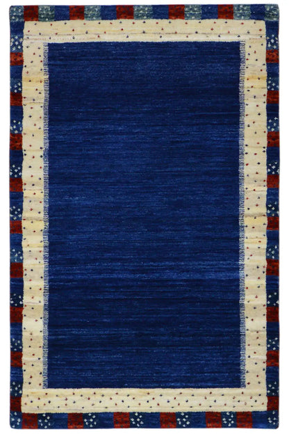 Gabbeh rug with a blue field and cream-colored border, red-and-blue edging
