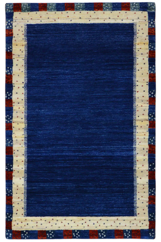 Gabbeh rug with a blue field and cream-colored border, red-and-blue edging