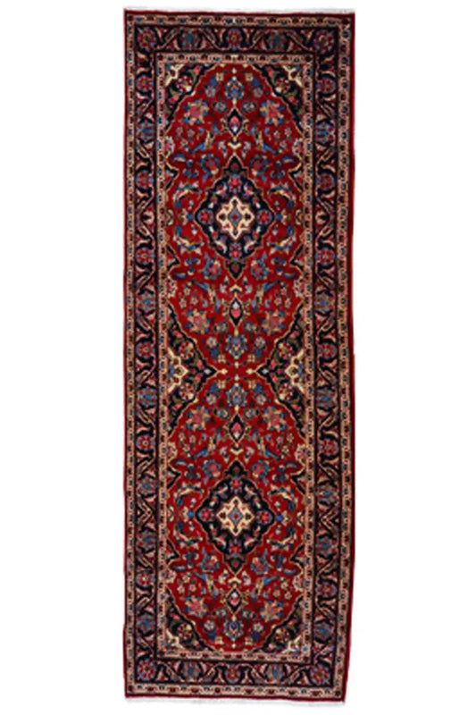Red Oriental rug with a blue-framed medallion on an elongated field