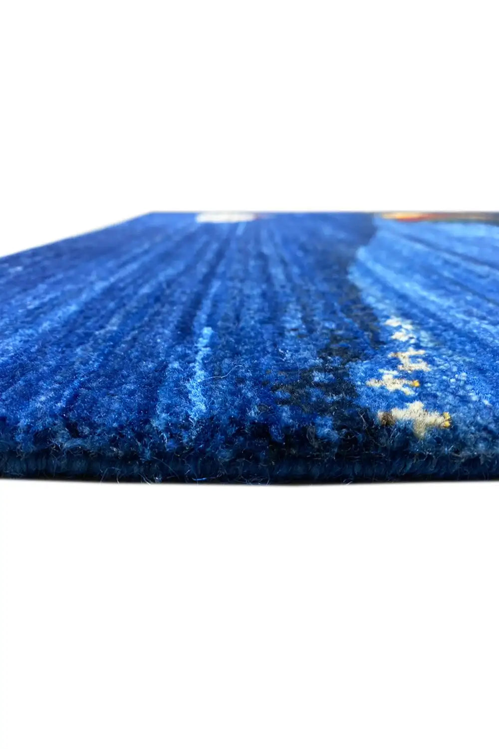 Gabbeh rug, close-up of the blue pile texture with a white and multicolored motif along the edge