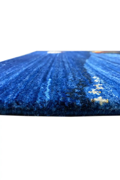 Gabbeh rug, close-up of the blue pile texture with a white and multicolored motif along the edge