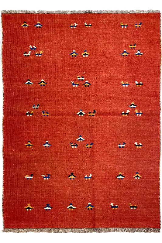Red kilim rug with rows of small multicolored patterns covering the surface and fringes