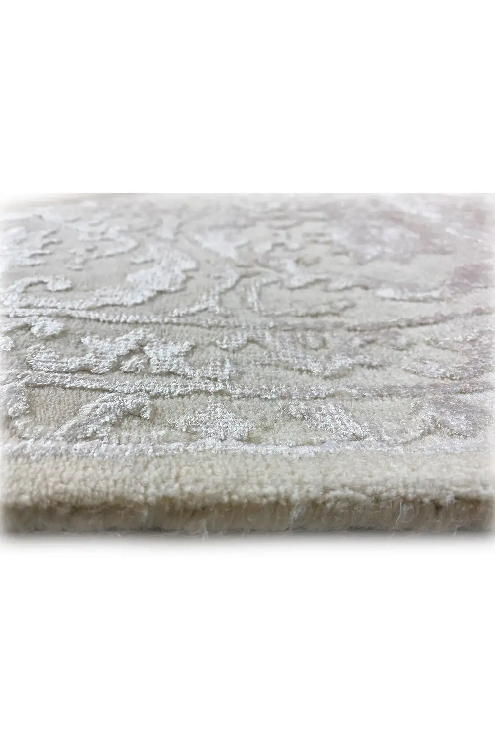 Light beige rug with woven-in ornaments and a short, velvety pile.
