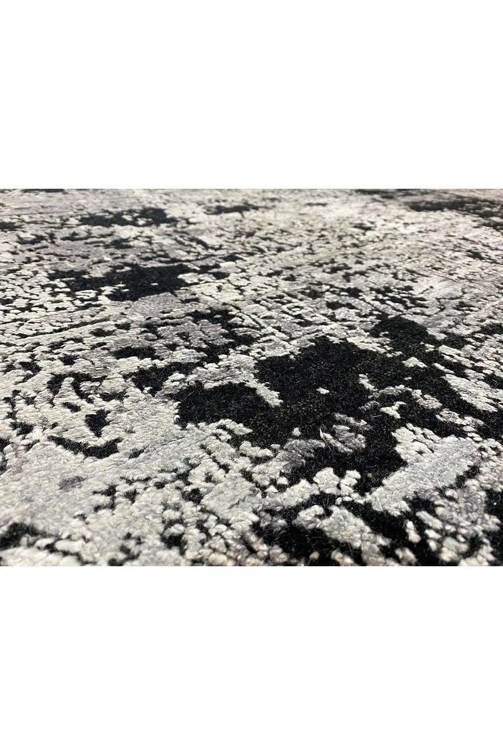 Rug with an abstract black, white and gray pattern, raised pile texture
