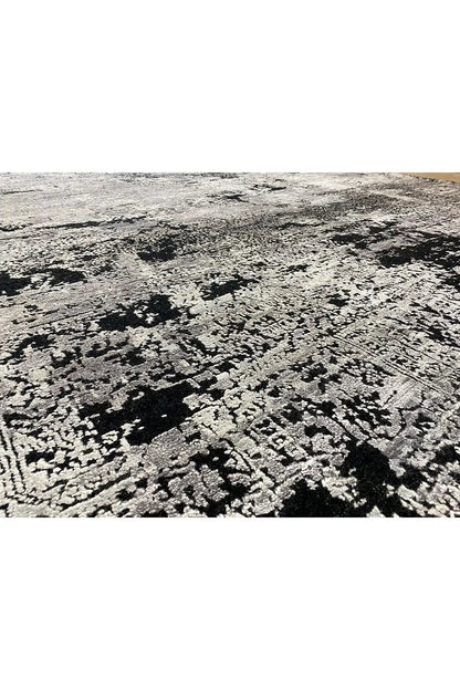 Rug with a large-scale abstract black, white and gray pattern, rough pile