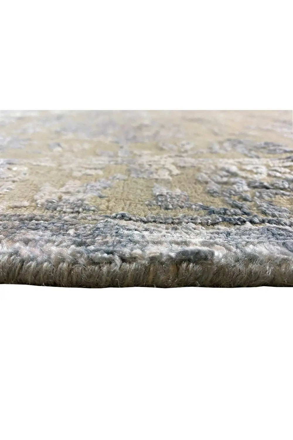 Designer rug edge view: dense pile with blue-gray and cream-colored areas