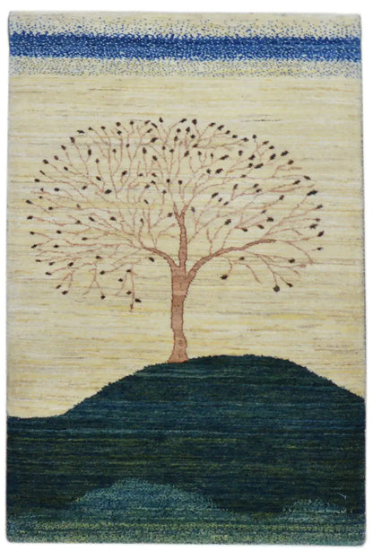 Gabbeh rug with a tree motif over a dark hill, beige background, blue-green accents