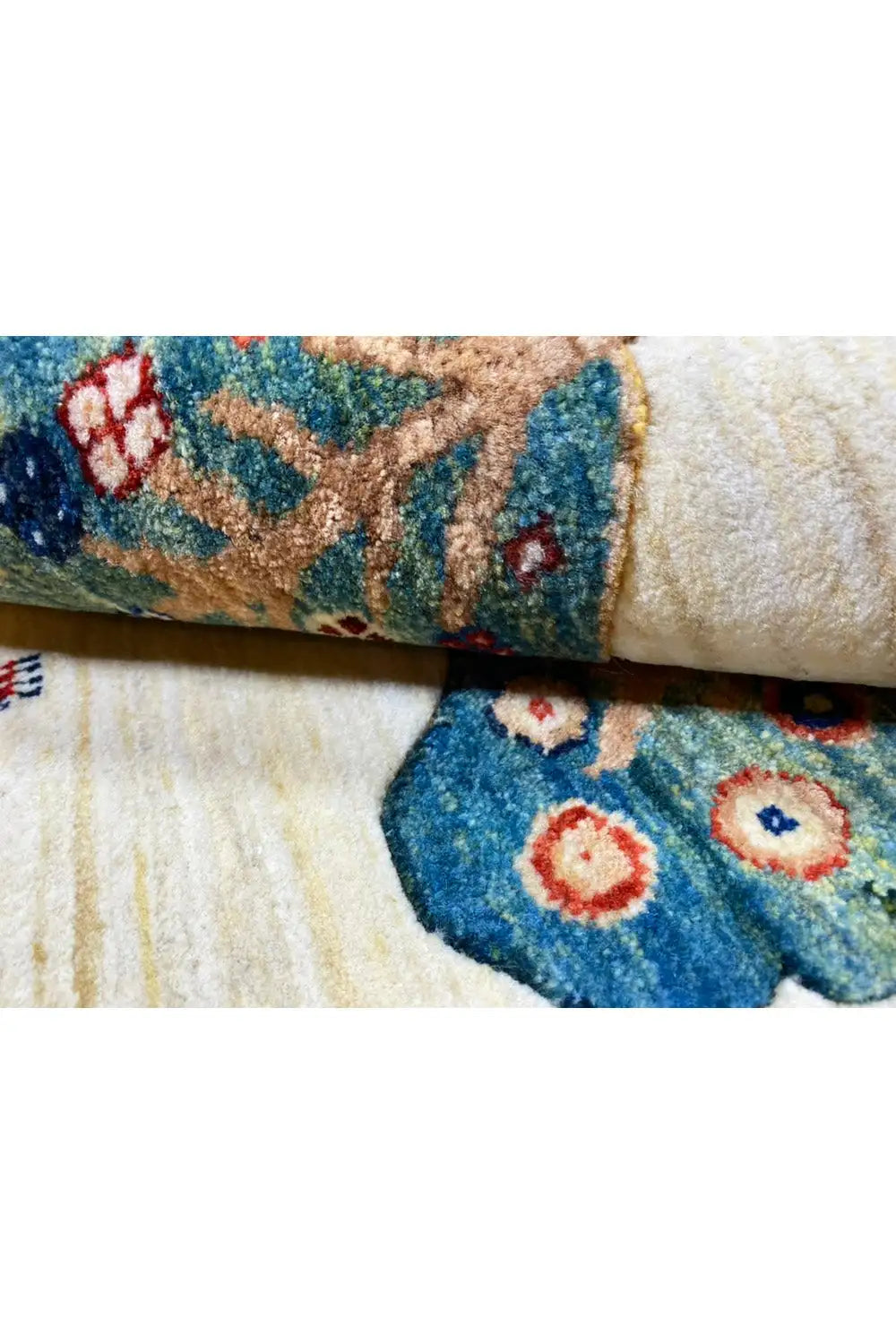 Gabbeh rug 119x75 cm close-up: folded corner with a blue tree and floral pattern