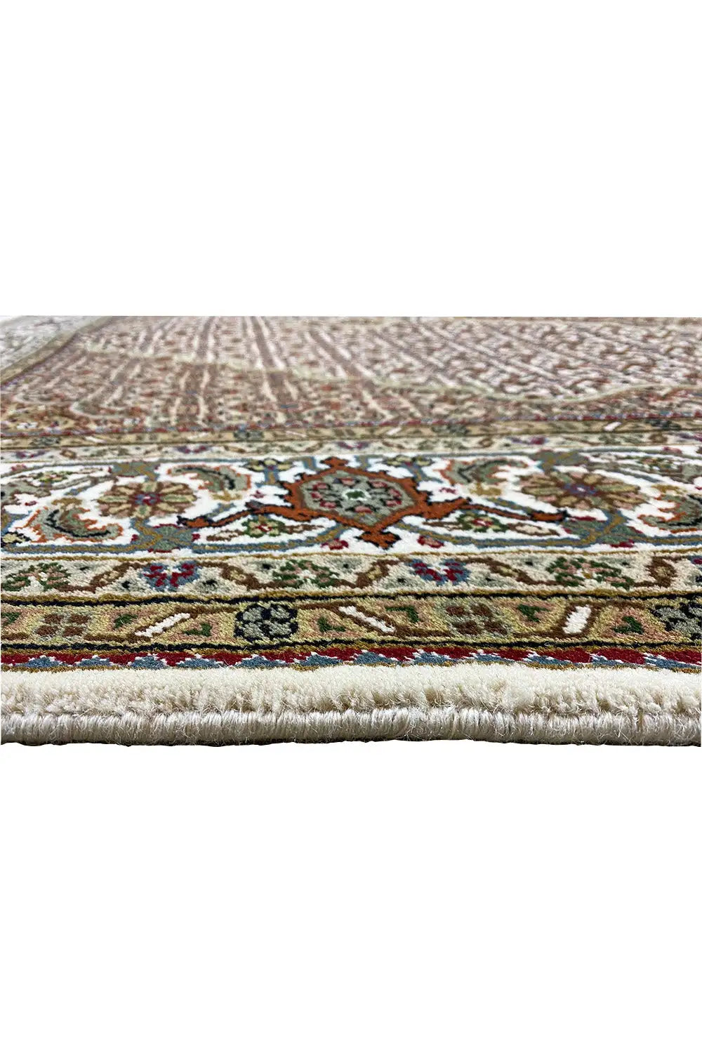 Close-up of a carpet edge with a multicolored border and fringes