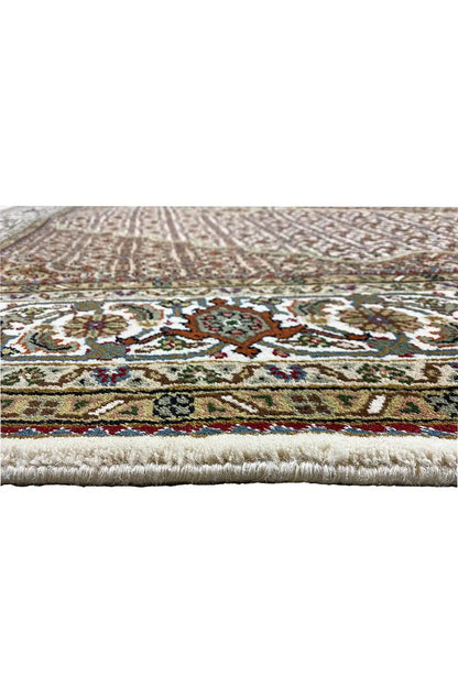 Close-up of a carpet edge with a multicolored border and fringes