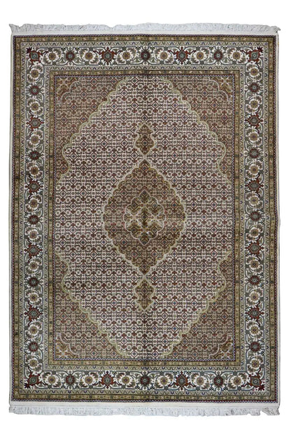 Oriental rug with a brown-gray background, ornamental medallion, and fringes along the edge