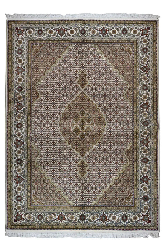 Oriental rug with a brown-gray background, ornamental medallion, and fringes along the edge