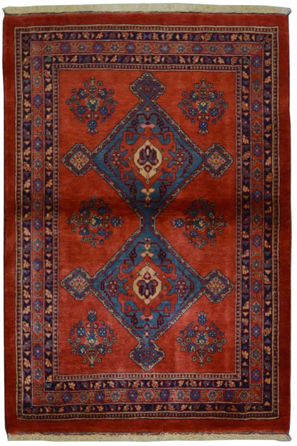 Red rectangular rug with a blue medallion and patterned border