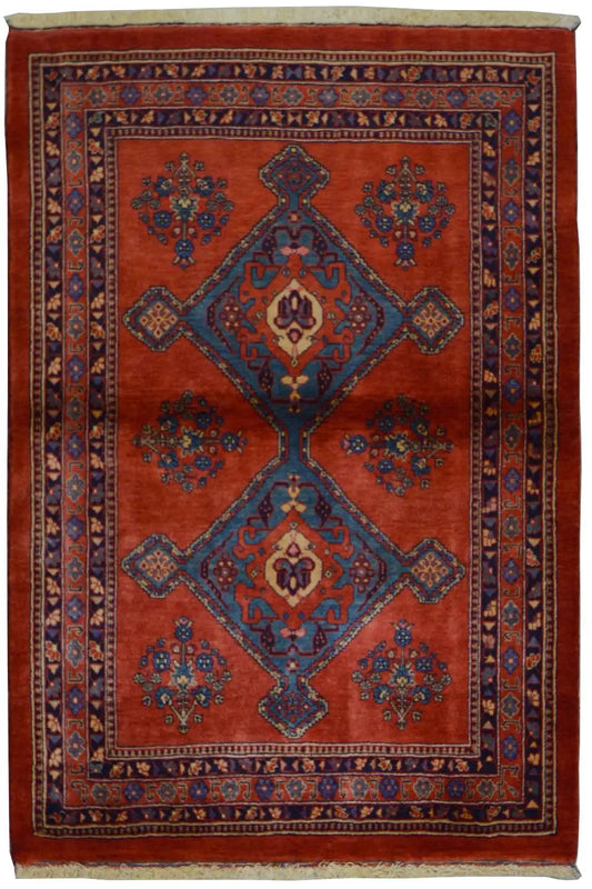 Red rectangular rug with a blue medallion and patterned border