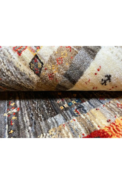 Gabbeh rug close-up of the weave structure: pile in gray, cream, and red