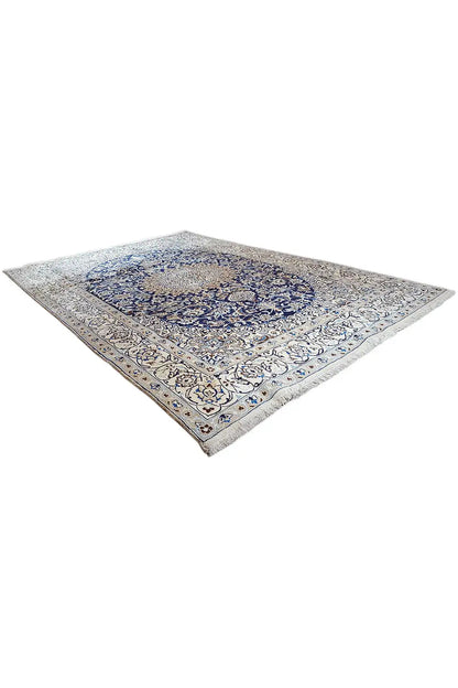 Triangle/diagonal view: beige Oriental rug with a blue central medallion.