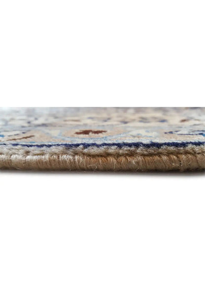 Close-up of the carpet edge with a woven border and visible pile, slightly frayed.