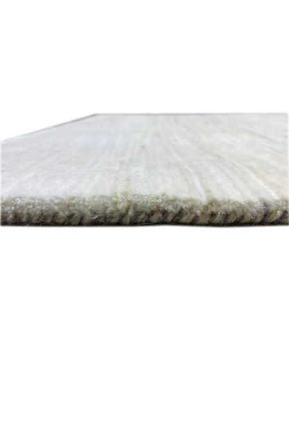 Gabbeh rug close-up: short-pile side with padded edge, light beige surface
