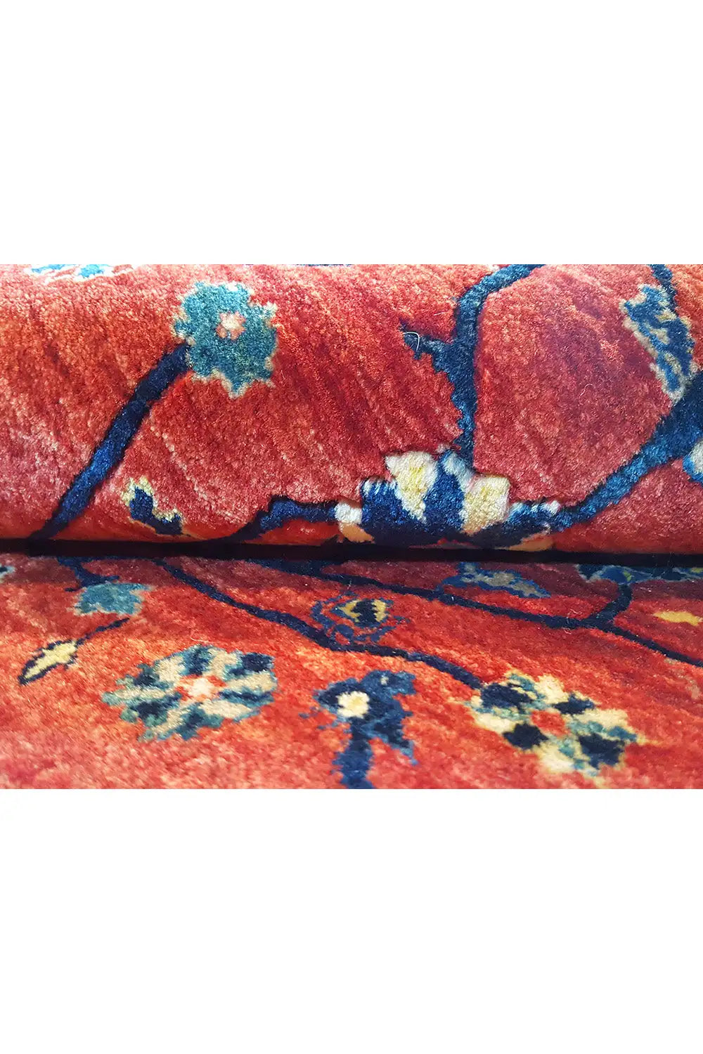 Red Oriental rug with a tree motif and floral ornaments, close-up.