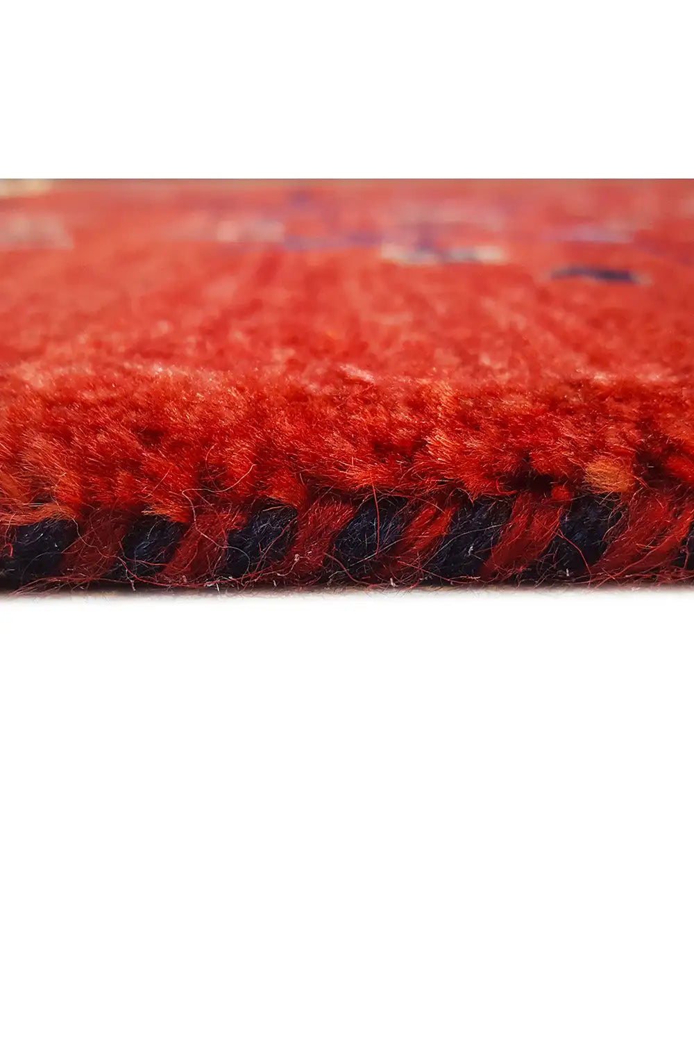 Reddish-brown rug with dark pile and beige fringes, close-up of the edge.