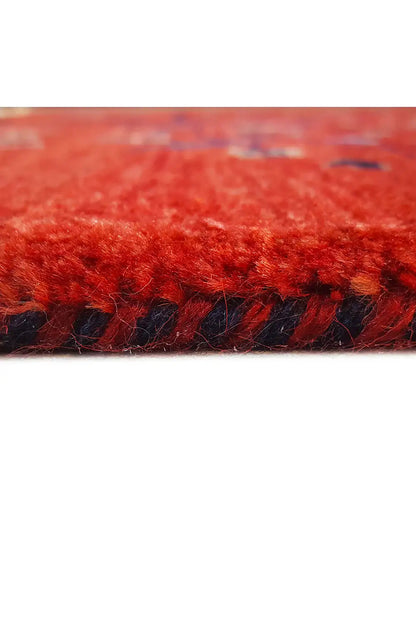Reddish-brown rug with dark pile and beige fringes, close-up of the edge.