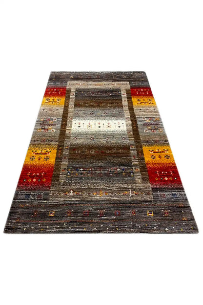 Gabbeh rug 129x80 cm, photographed at an angle: gray rectangle with decorative borders in red/yellow