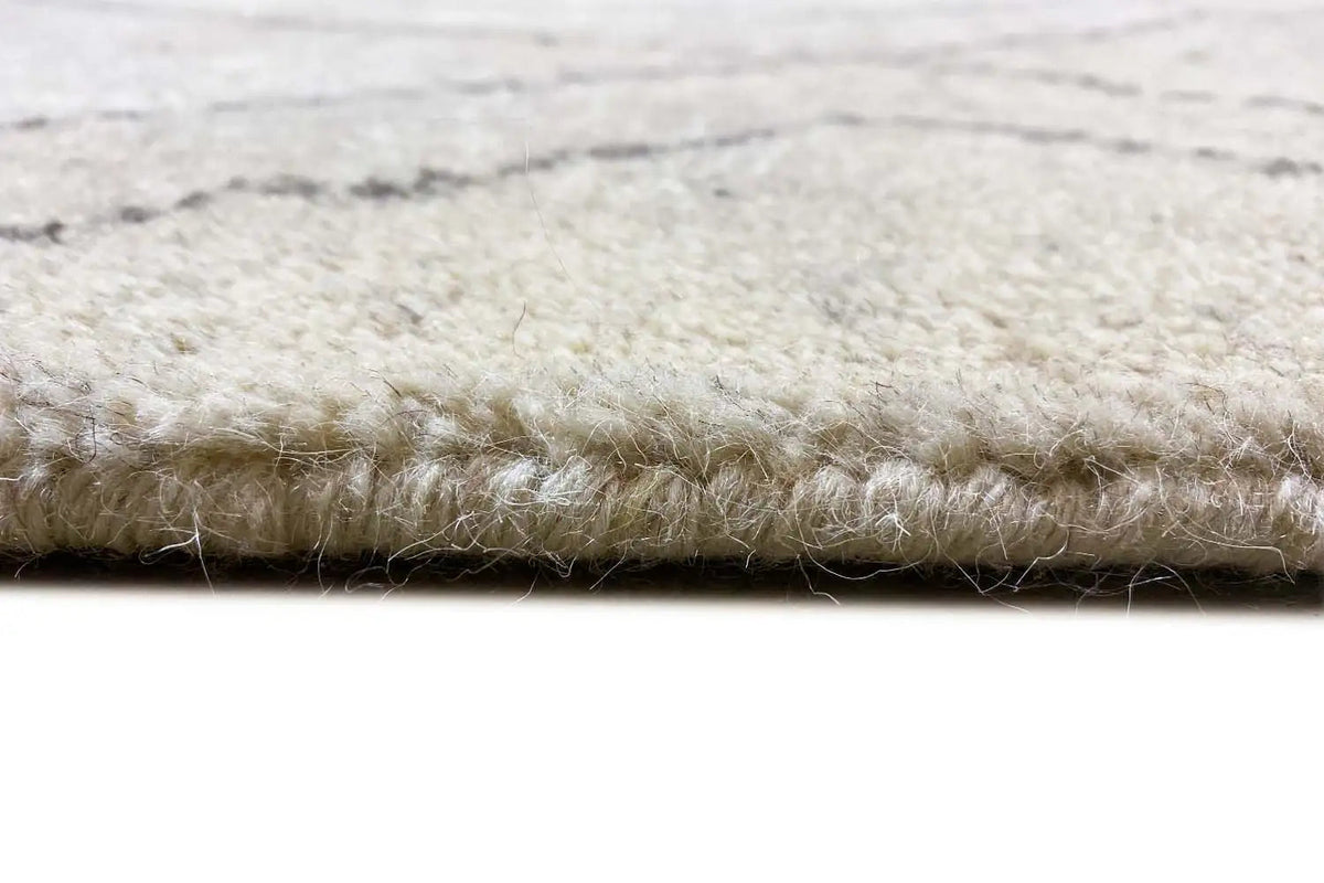 Berber rug detail: short pile with a bound edge, light beige and gray