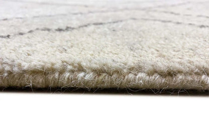 Berber rug detail: short pile with a bound edge, light beige and gray