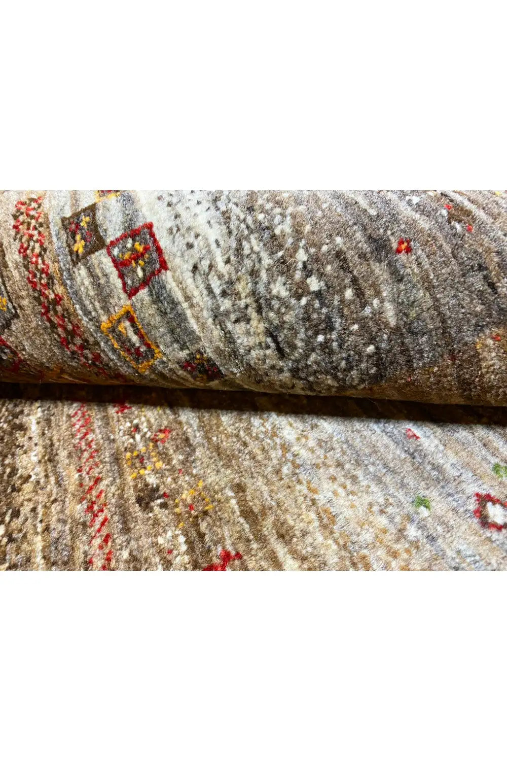 Gabbeh rug: coarse-textured pile, cream-colored base, and colorful threads