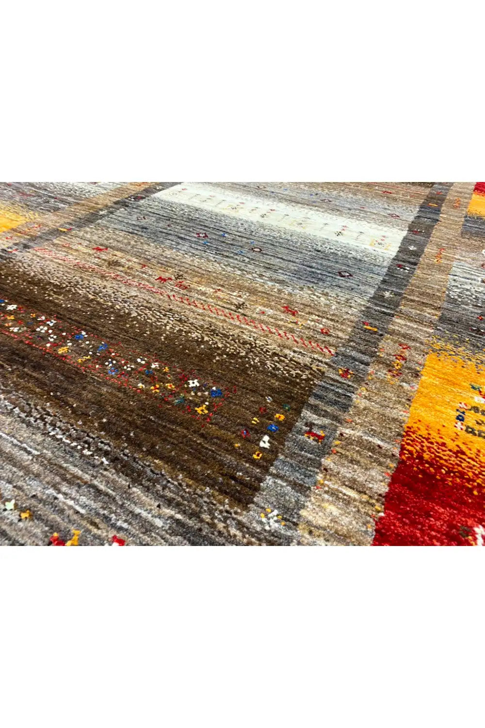 Gabbeh rug detail view: gray-brown pattern with ochre and red accents