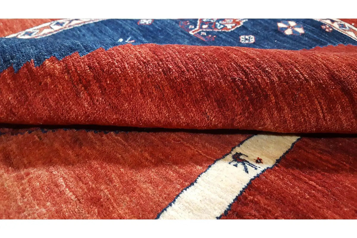 Red-and-blue carpet with knitted pile, cream-colored decorative braid, and blue border motif