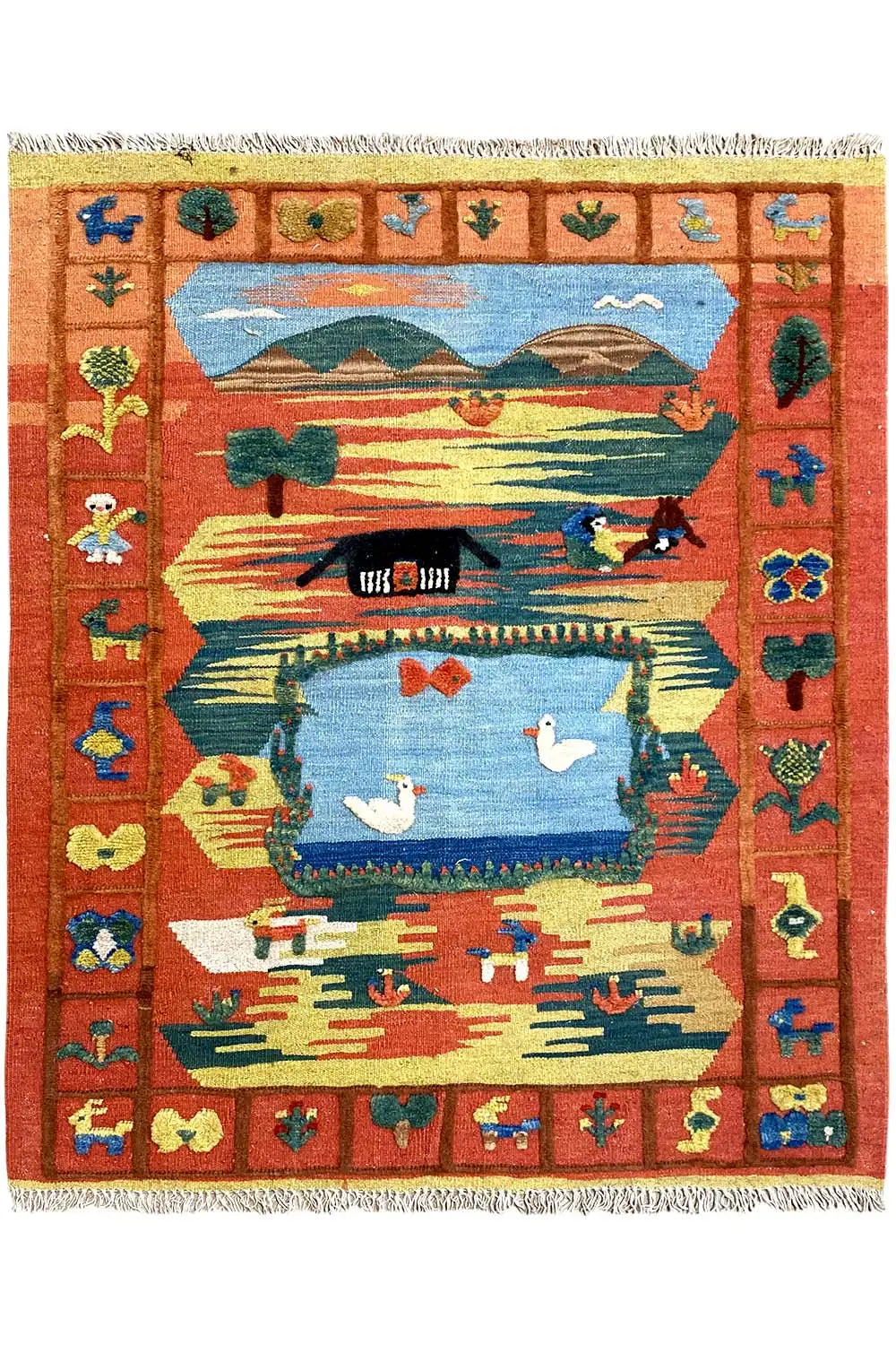 Brick-red kilim rug with a landscape motif, birds, a framed border and fringes