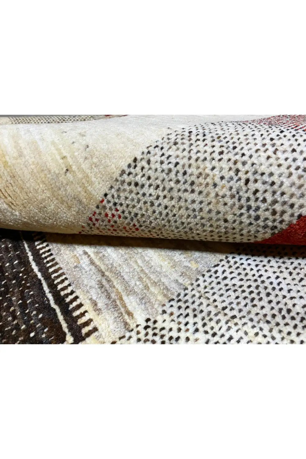 Gabbeh rug close-up: textured woven edge, beige background with black and red areas