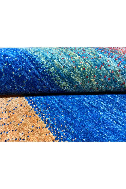 Gabbeh rug (168x105 cm) edge detail: blue pile area and orange triangle